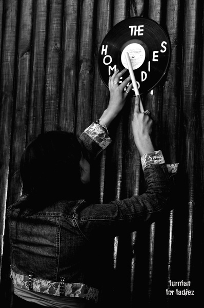 PR-менеджерка гурту Роксі вішає платівку-прикрасу на стіну.